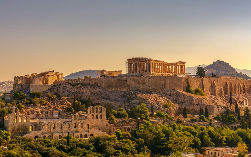 Golden-hour view of the Acropolis and Parthenon in Athens above the surrounding hills