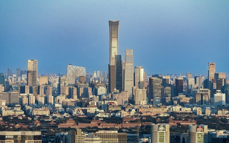 Beijing skyline with the CITIC Tower and CCTV Headquarters rising above traditional Chinese rooftops under a clear sky