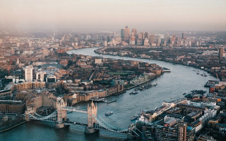 Aerial view of Tower Bridge and the Thames toward Canary Wharf at dusk