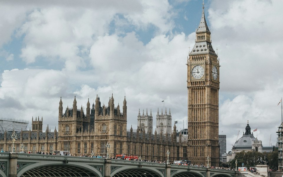 Big Ben and the Houses of Parliament seen from Westminster Bridge with a red double-decker bus in the foreground