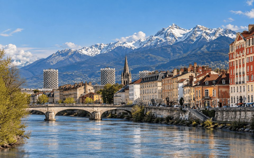 Grenoble along the Isère with a stone bridge and snow-capped Alps beyond