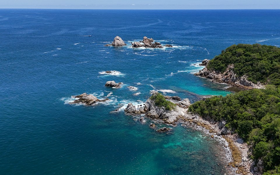 Aerial view of Huatulco's rocky green coastline and turquoise Pacific bays