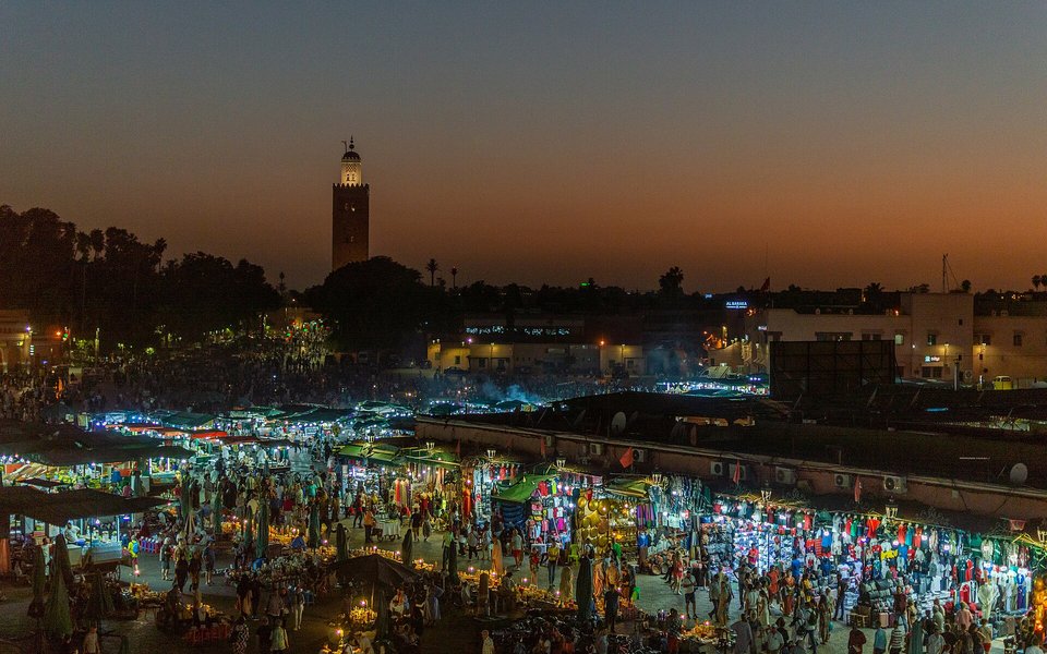Jemaa el-Fna square in Marrakech with market stalls, crowds and the medina skyline