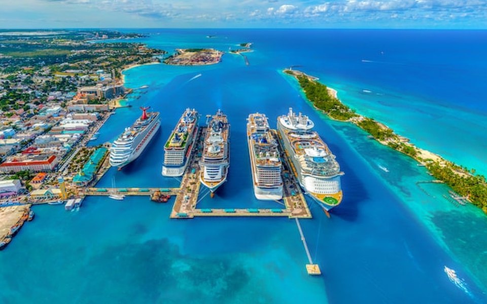 Aerial view of cruise ships docked in turquoise water at Nassau harbour with Paradise Island and the city coastline