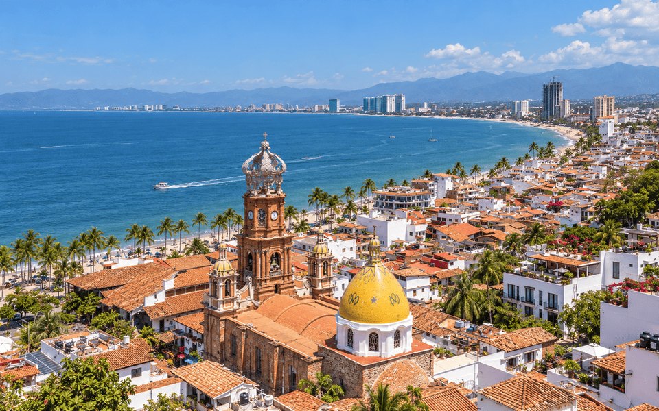 Aerial view of Puerto Vallarta with the crown-topped Church of Our Lady of Guadalupe, orange-tiled rooftops and Banderas Bay
