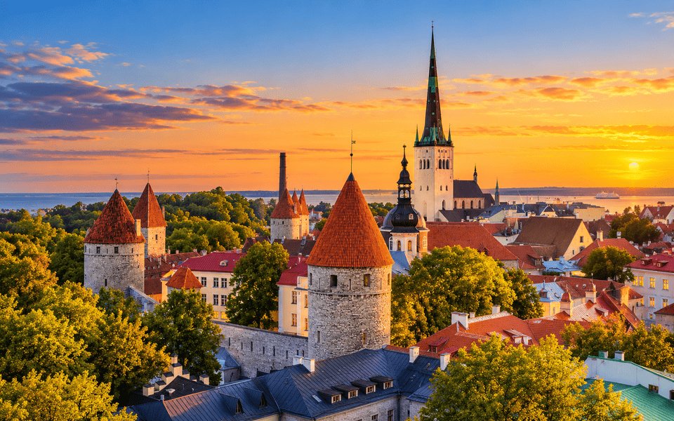 Sunset over Tallinn Old Town with medieval towers, red rooftops and the Baltic Sea beyond