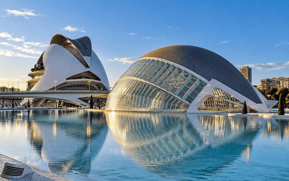 Futuristic white architecture of the City of Arts and Sciences in Valencia reflecting in a calm turquoise pool under a clear sky