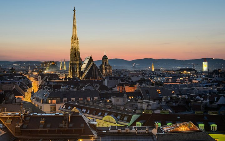 St Stephen's Cathedral and Vienna rooftops at dusk with hills on the horizon