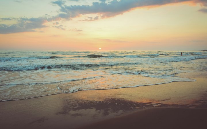 Sunset waves on a sandy beach for a February flight alert